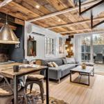 Wohnraum mit Essbereich, Sofa und Holzdecke. Durchgang zur Terrasse mit Garten.