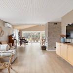 Living room with sofa, TV, and view of terrace.