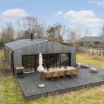 Modern wooden cabin with large terrace area and garden.