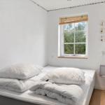 Bedroom with bed, window, and wall decor.