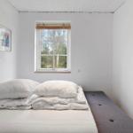 Bedroom with bed, window, and art on the wall.