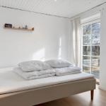 Bedroom with bed, window, and wooden floor.