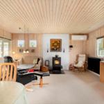 Living room with fireplace, sofa, chairs, and wood paneling.