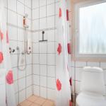 Bathroom with shower, toilet, and sink. Window with frosted glass.