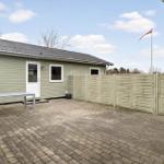 Backyard with patio, table, and Danish flag. Wooden fence and small house.