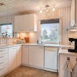 Kitchen with wooden walls, sink, dishwasher, and window