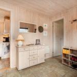 Entrance area with shoe rack, coat hooks, and view into the kitchen.