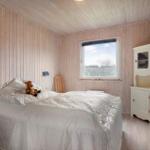 Bedroom with wooden walls, bed, TV, and window.