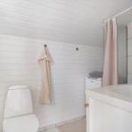 Bathroom with toilet, sink, and shower with pink curtain.