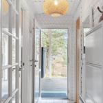 Hallway with white walls, tiled floor, and ceiling light. Corridor to the terrace.