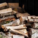 Stack of split firewood on a wooden deck.