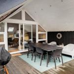 Deck with table, chairs, and seating. Access to the interior of the house.