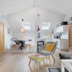 Living area with dining space, kitchen, and sleeping area under a roof