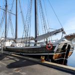 Segelschiff am Hafen mit Rettungsring und Masten.