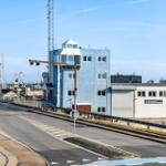 Blauer Turm neben Hafen mit Booten und Windkraftanlagen