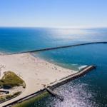 Aerielansicht eines Strandes mit Steilufer und Meer.