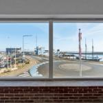 Großes Fenster mit Blick auf Hafen und Straßenkreuzung.