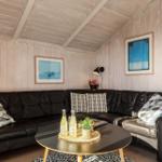 Schwarzes Sofa mit Kissen, runder Tisch und Holzwand im Wohnzimmer.