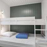 Room with bunk bed, window, and wall lighting.