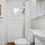 Bathroom with toilet, sink, and shower with curtain.