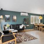 Living and dining area with sofa, chair, table, and wall art.