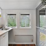 Kitchen with windows, worktop, and view of the forest.