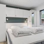 Bedroom with white bed, closet, and window to the outdoors.