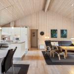 Modern kitchen with dining area and living room with sofa and dining table.