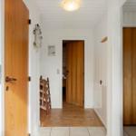 Hallway with wooden doors and white walls. Wooden floor and ceiling.