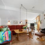 Living room with red sofa, wooden table, and leather recliner.