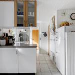 Kitchen with white cabinets, refrigerator, and kitchen counter