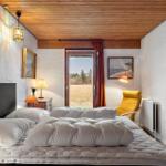 Schlafzimmer mit Bett, Fenster und gelber Sessel.