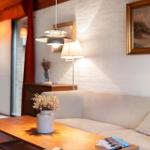 Wohnzimmer mit Sofa, Tisch, Lampe und Bild an der Wand.