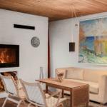 Wohnzimmer mit Kamin, Sofa, Tisch und Wandbild.