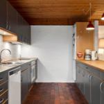 Küche mit Holzdecke, Arbeitsplatten und Küchengeräten.