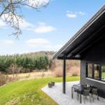 Modern house with terrace, garden, and forest view.