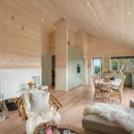 Living and dining area with fireplace, wooden ceiling, and dining set.