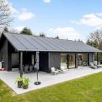 Modern villa with terrace, garden, and glass facade. Outdoor seating and plants.