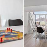 Tisch mit Spiel und Sitzgelegenheiten in einem hellen Raum mit Fenster und Leiter.