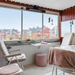 Terrasse mit Sitzgelegenheiten und Blick auf rote Häuser.