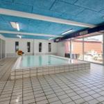 Innenpool mit blauem Deckenverkleidung und großem Glasbereich.