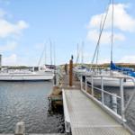 Hafen mit Segelbooten und Steg zum Wasser.