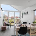 Esszimmer mit Tisch, Stühlen und Blick auf Balkon und Garten.