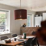 Essbereich mit Holztisch, schwarzen Stühlen und hängender Lampe.