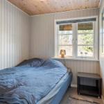 Schlafzimmer mit Bett, Fenster und Nachttisch.
