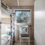 Bedroom with bunk bed, chair, and window with view.