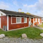 Red wooden house with white window frames and garden