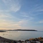 Beach with rocks and marina in the background