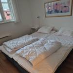 Bedroom with double bed, window, and wall art.