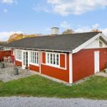 Red wooden house with terrace and grill area in autumn